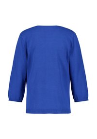 Blå stickad tröja med avslappnad passform, trekvartslånga ärmar och ribbad nederkant. Slät textur och enkel design, bakvy visas.