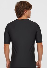 Svart kortärmad t-shirt med en mjuk, elastisk textur och rund halsringning, med platta sömmar och en figurnära passform.