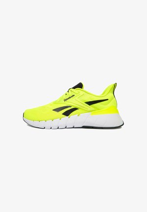 Fluoreszierender gelber Reebok-Laufschuh mit schwarzen Logoakzenten und dicker, weiß segmentierter Sohle auf weißem Hintergrund.