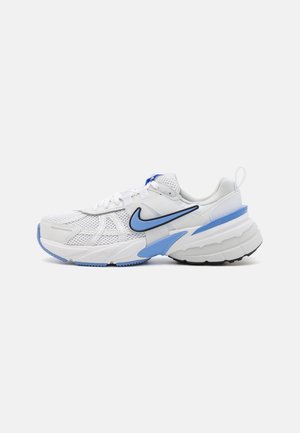 Chaussure de running Nike blanche et bleu clair avec une tige en mesh, une semelle épaisse et un grand logo Swoosh bleu sur le côté.