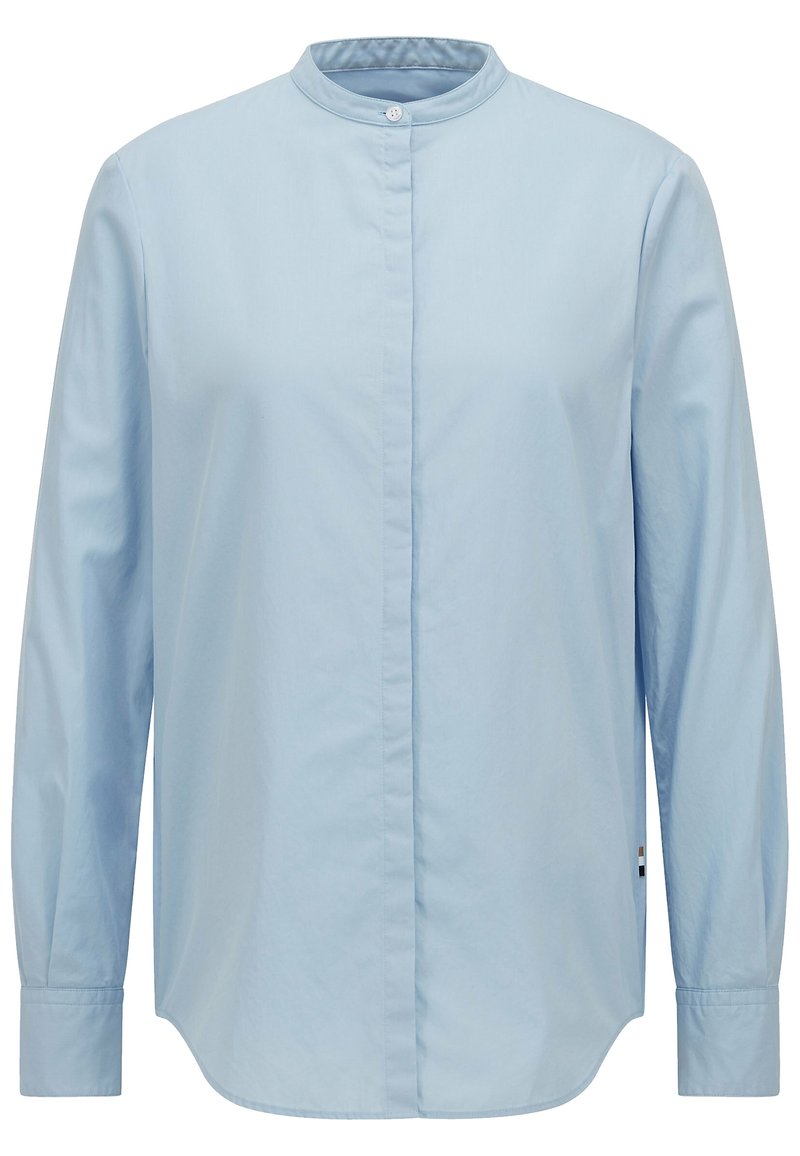 Camicia a maniche lunghe blu chiaro con colletto a banda, chiusura a bottoni al collo e orlo arrotondato. Tessuto di cotone liscio senza motivi o dettagli.