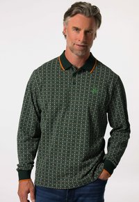 Pánská polokošile s dlouhým ruk ávem v tmavě zelené barvě, s složitým bílým vzorem, oranžovými akcenty na límečku a zeleným logem na hrudi.
