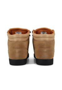 Braune Wildleder-Ankle Boots mit gepolstertem Kragen, schwarzen Gummisohlen und orangefarbener Fütterung. Zwei Metallösen für die Schnürsenkel an jedem Boot.