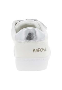 White sneaker with a smooth surface, metallic silver heel accent, and gold "KAPORAL" logo. Features a padded collar and rubber sole.