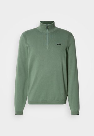Svetlozelený pulóver so zipsom na krku vyrobený z pleteniny. Má dlhé rukávy, ribbovaný povrch na pleciach a čierne logo "BOSS" na hrudi.