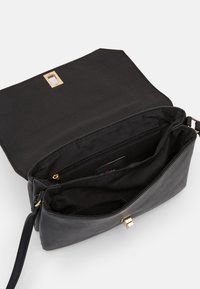 Borsa nera con esterno in pelle liscia, accessori in oro e un interno spazioso dotato di più scomparti e di una tasca con zip.
