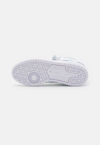 White sneaker sole with textured circular patterns. Features a light blue accent and branding detail near the heel. Durable rubber material.