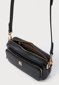 Μαύρη δερμάτινη τσάντα χιαστί με δύο τμήματα με φερμουάρ, χρυσές λεπτομέρειες και υφή. Περιλαμβάνεται ρυθμιζόμενος ιμάντας.