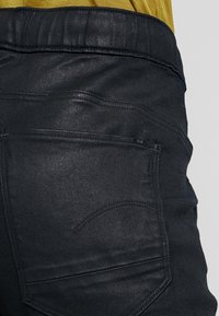 Svarta denimjeans med en slät textur, med en bakficka med subtila söm detaljer och en smal midjebandsdesign.