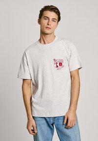 Gray cotton t-shirt with short sleeves, featuring a red graphic print that reads "OFF-LINE!" on the left chest. Casual fit, soft texture.