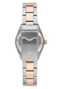 Orologio in acciaio inossidabile con un accento in oro rosa. Caratterizzato da un corpo elegante e angolare, una corona prominente e un logo inciso sulla chiusura.