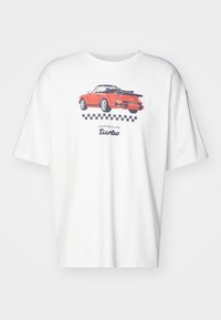 Valge puuvillane T-särk, millel on joonistus punasest sportautost koos "Porsche turbo" tekstiga ja musta ruudulise mustriga kujunduse all.