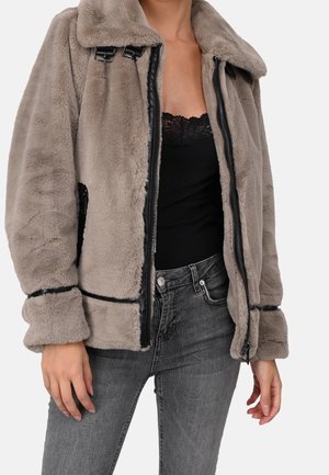 Chaqueta de piel sintética en gris claro con cierre de cremallera negra, gran cuello y costuras de acento. Cuenta con bolsillos laterales y mangas con puños.