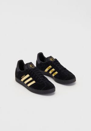 adidas Originals GAZELLE JUDE BELLINGHAM - Zapatillas de entrenamiento - black/gold-coloured