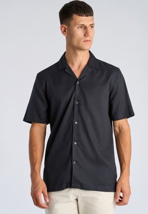 Czarna koszula z krótkim rękawem, z kołnierzykiem i zapinana na guziki z przodu. Teksturowana tkanina o subtelnym połysku, z małym logo na piersi.