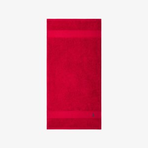 Serviette de bain en coton rouge avec une surface texturée, un détail de double bande en haut et un petit logo dans le coin inférieur.
