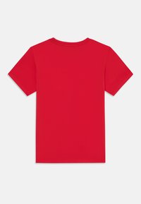 Camiseta de algodón roja con mangas cortas, cuello redondo y una textura suave. Sin patrones ni gráficos visibles, vista trasera lisa.