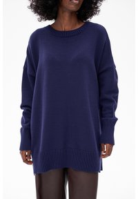 Navyblauwe oversized gebreide trui met ribgebreide ronde hals en manchetten, met een gestructureerde afwerking en zijsplitten aan de onderkant.