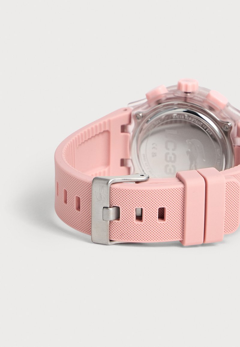 Pink strukturiertes Silikon-Uhrenarmband mit silberner Schnalle und klarem Uhrengehäuse, von hinten auf weißem Hintergrund gezeigt.
