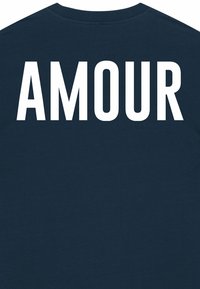 T-shirt bleu marine avec un texte blanc en gras "AMOUR" au dos. Fabriqué en coton doux, avec un design classique à col ras du cou et des manches courtes.