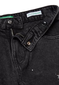 Vaqueros de mezclilla negros con corte recto. Las características incluyen una cremallera, cierre de botón y pequeños strass decorativos en el frente.