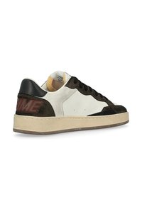 Sneakers con lacci in una combinazione di suede nero e pelle bianca, con suola beige e branding in rilievo rosso sul tallone.