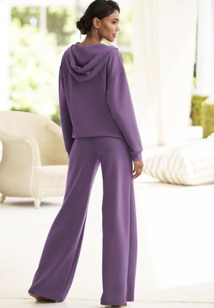 Purple, soft hoodie with a large hood, paired with wide-leg pants in the same material, showcasing a relaxed fit and seamless design.