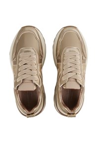 Beige leren sneakers met dikke zolen, beige veters en subtiele metalen zijkanten, weergegeven vanuit een bovenaanzicht.