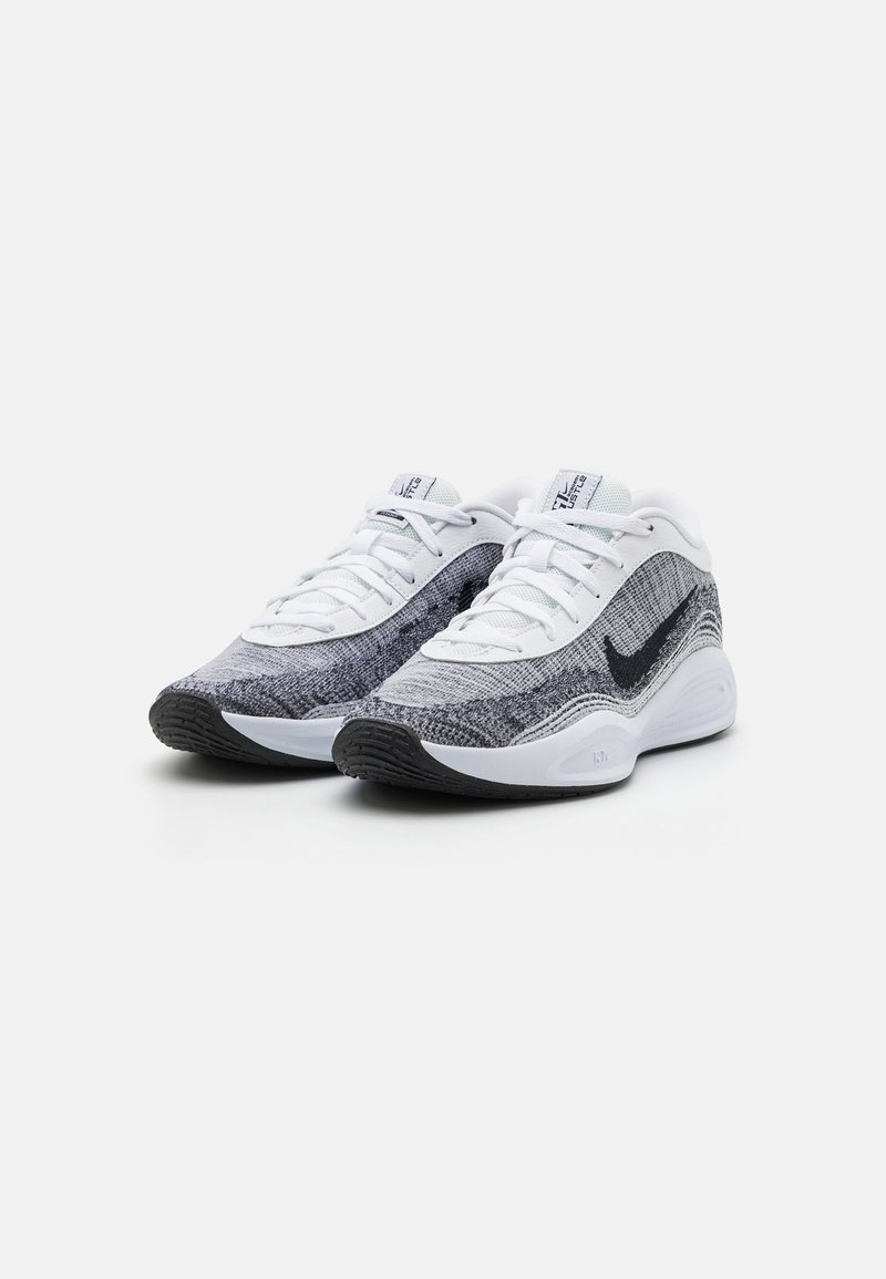 Baskets de sport avec une tige en tricot gris et blanc, des accents noirs et une semelle texturée. Équipées de lacets et d'un col rembourré pour un meilleur maintien.