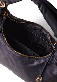 Black leather handbag with textured exterior and gold-tone hardware. Interior features a smooth black lining and a brand label.