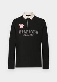 Melnas garas piedurknes polo krekls ar beigu apkakli, uz kura ir uzraksts "HILFIGER Racing Club" baltā krāsā un sarkans izšūts logo detalizējums.