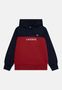 Felpa con cappuccio rossa e blu navy con tasca a marsupio, con la scritta "LACOSTE" in bianco e un logo verde sul petto. Tessuto in misto cotone.