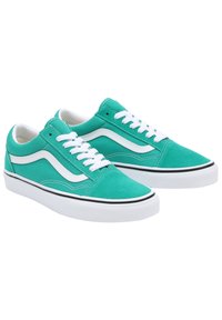 Green canvas sneakers featuring white laces, a white side stripe, and a black trim along the sole. Classic low-top design.