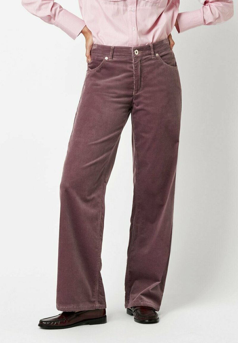 Corduroy pants in deep mauve, featuring wide legs, five pockets, and subtle texture. Paired with dark, glossy shoes and a pink striped shirt.