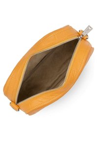 Sac en cuir jaune avec une forme structurée, doté d'une fermeture éclair, d'une texture lisse et d'une doublure intérieure beige. Quincaillerie de fermeture éclair visible.