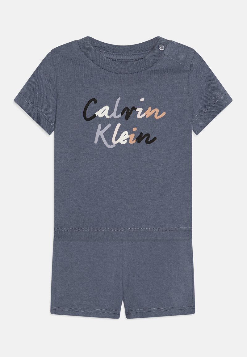 Niebieski body z krótkim rękawem wykonane z bawełny, z szarym, brzoskwiniowym i czarnym logo "Calvin Klein". Posiada zapięcie na napy na ramieniu oraz elastyczny pas.