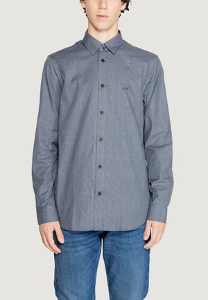 Camicia a maniche lunghe grigia, con bottoni, a fantasia discreta, colletto a punta e bottoni neri. Presenta un logo sul lato sinistro del petto.