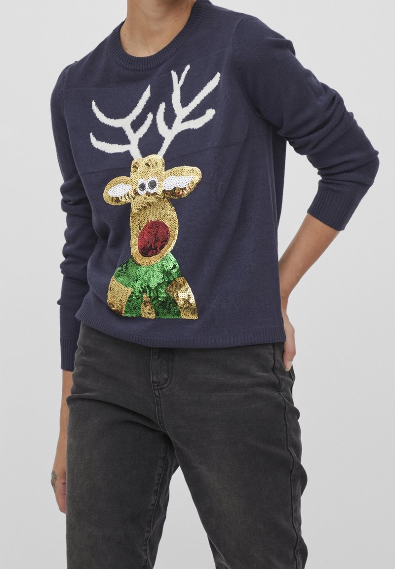 Pull en maille bleu marine avec un motif de renne en sequins dorés et verts. Col rond classique et poignets côtelés.