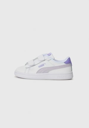 Baskets blanches avec deux bandes Velcro, accents violets et une bande latérale texturée. Dotées d'une semelle en caoutchouc et d'un collier rembourré.