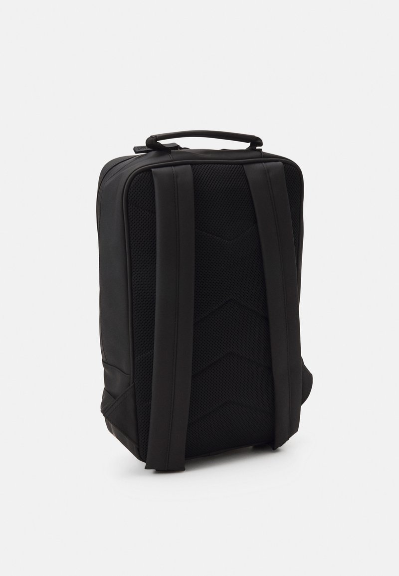 Zwarte rugzak met een gestructureerd oppervlak, voorzien van brede schouderbanden en een strakke vormgeving. De achterkant heeft een chevronpatroon voor extra ondersteuning.