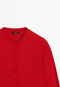 Červený kardigan s kulatým výstřihem, se šesti knoflíky vpředu. Štítek s nápisem "Massimo Dutti." Jednoduchý, klasický pletený design.