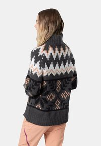 Strickkragenpullover mit geometrischem Muster in Schwarz, Weiß und Pfirsich, mit einem strukturierten Rippbund und lässiger Passform.