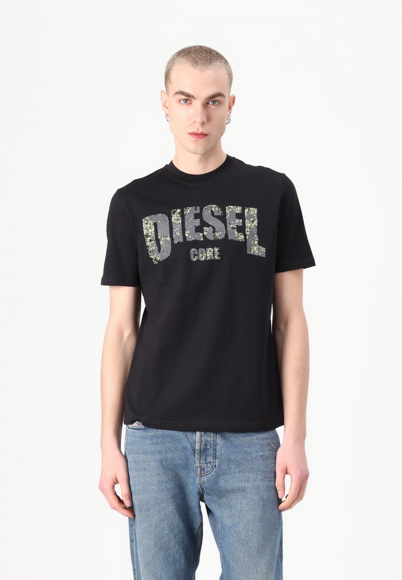 Melnas kokvilnas T-krekls ar apaļu kaklu. Uz priekšpuses ir teksturēts "DIESEL CORE" logo sudraba un zaļos toņos.