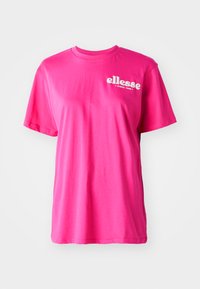 T-shirt rose vif à manches courtes avec un col rond, une coupe décontractée et un logo "ellesse" blanc sur le devant. Fabriqué en coton doux.