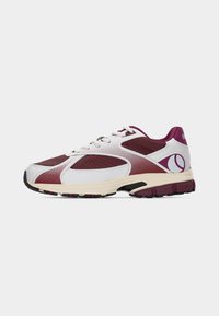 Baskets athlétiques bordeaux et blanches avec lacets sur le devant, semelle amortie et un logo circulaire près du talon, vues de côté.