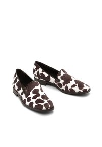 Lehmustada mustriga loafers, millel on pehme tekstuur, ümar nina, madal konts ja pruunid aktsendid, valmistatud pehmest kangast.