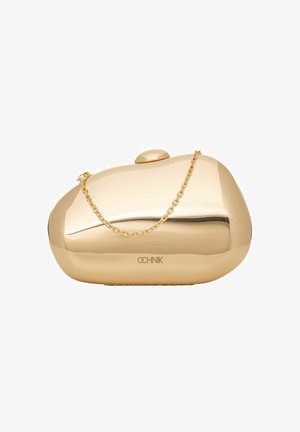 Mała błyszcząca złota kopertówka z zaokrąglonymi krawędziami i krótkim złotym łańcuszkiem do trzymania, wyposażona w zapięcie zatrzaskowe i logo marki.