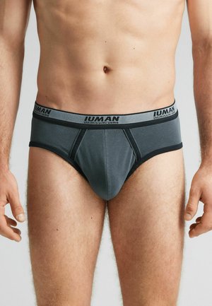 Graue Herrenunterhosen aus glattem Gewebe mit einem kontrastierenden Bündchen, das den Markennamen trägt. Das Design umfasst einen vorderen Beutel und elastische Ränder.