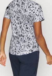 Camisa de manga corta en tela gris claro con patrón abstracto negro. Presenta un dobladillo redondeado y un ligero estiramiento para mayor comodidad.