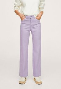 Pantalons larges de couleur violet clair en mélange de coton, avec une taille haute et une texture lisse, assortis à des chaussures à plateforme beiges.